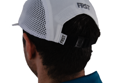 Person wearing a white cap with 'FIRST' branding on a white background