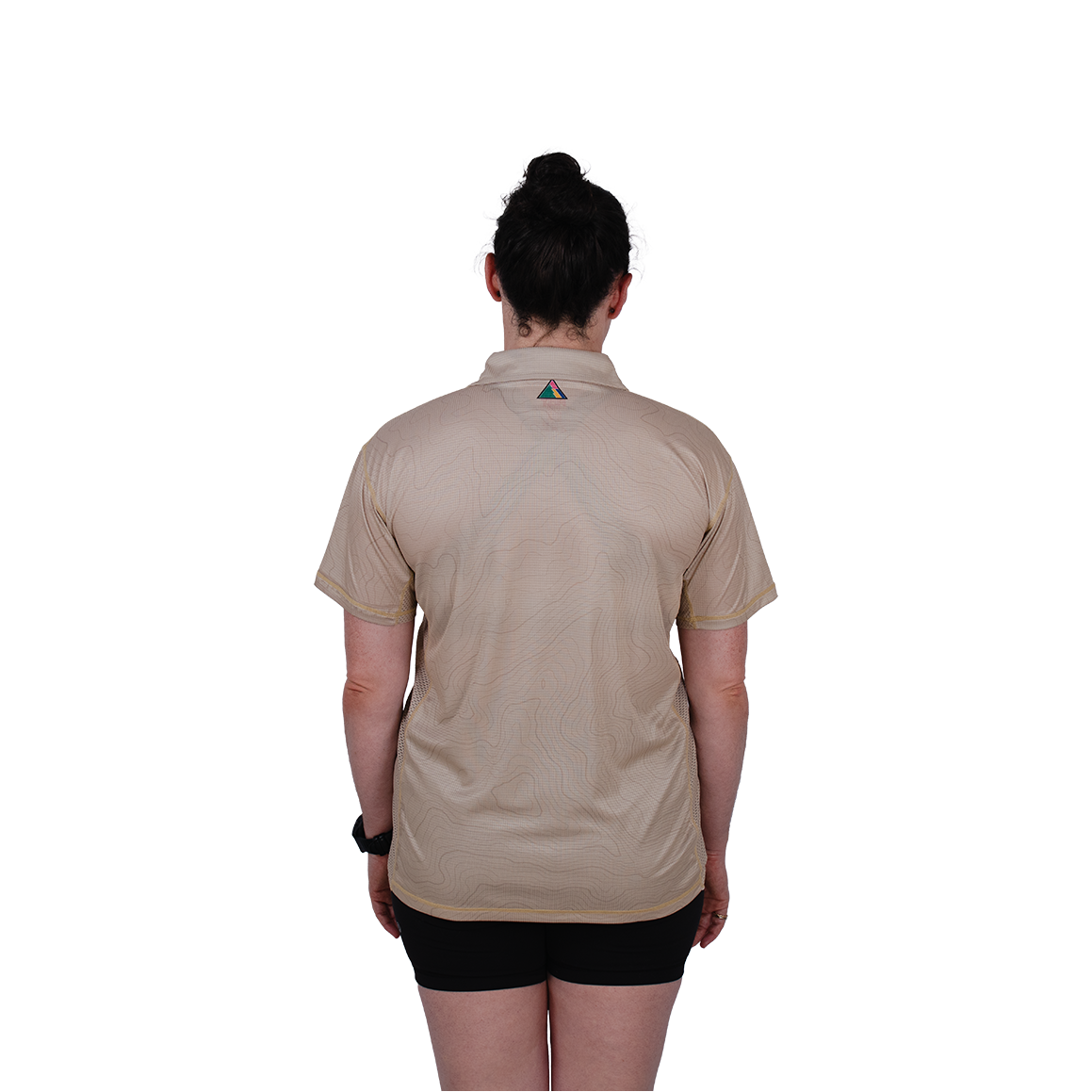 Person wearing a beige shirt with a logo on the back, standing against a white background