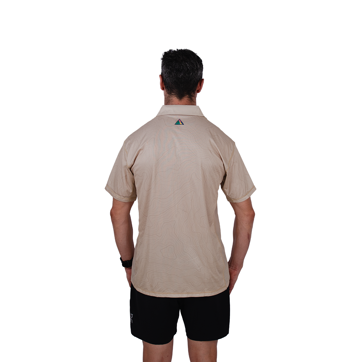Man wearing a beige trail running shirt with a logo on the back against a white background