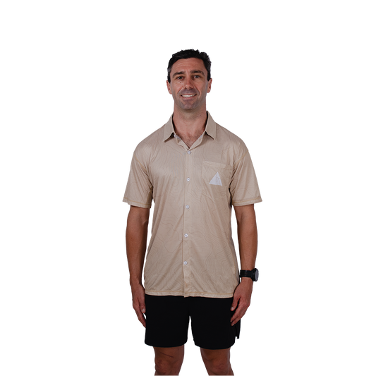 Man wearing a beige short-sleeve shirt with a logo on a white background