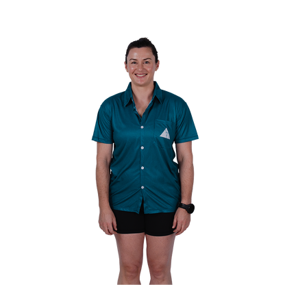 Woman wearing FRST trail running shirt in Tidefall blue with mountain logo, paired with black shorts