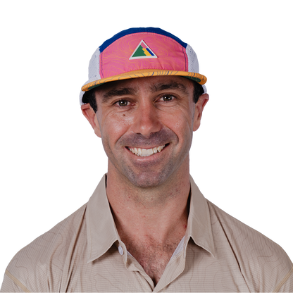 Man wearing a colorful cap with a FRST logo on a white background